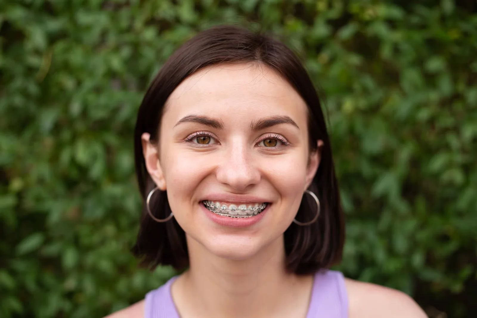 Young woman with braces smiling outdoors